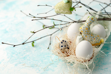 Easter scene with spring fresh greenery branches, rabbit and box of eggs, springtime festive background