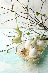 Easter scene with spring fresh greenery branches, rabbit and nest of eggs, springtime festive background