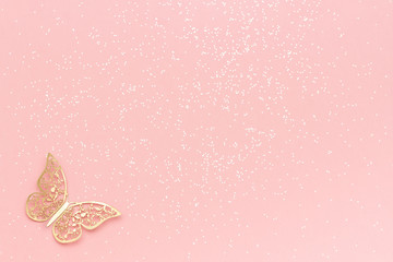 Sparkles glitter and gold tracery butterfly on pink pastel trendy background. Festive background,...