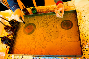 Hand drawing with stick stained inks on water