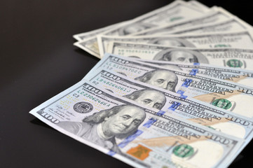 fan of american dollars on black background. financial concept