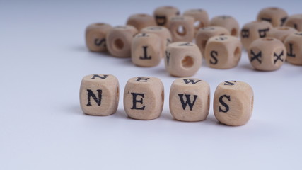 NEWS inscription on wooden alphabet over white background with selective focus