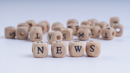 NEWS inscription on wooden alphabet over white background with selective focus