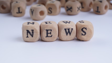 NEWS inscription on wooden alphabet over white background with selective focus