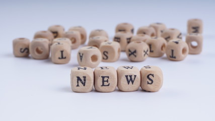 NEWS inscription on wooden alphabet over white background with selective focus