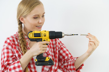 Woman drilling in wall