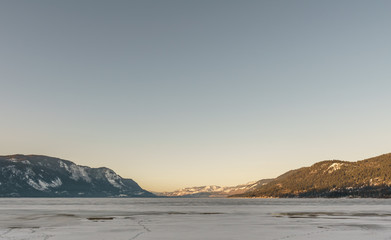 Fototapeta na wymiar Cold morning landscape of frozen Little Shuswap Lake British Columbia Canada.
