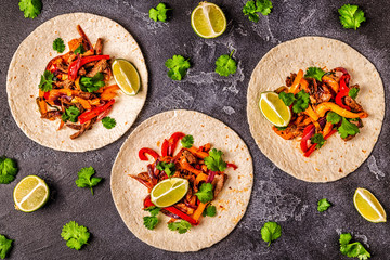 FAJITAS with colored pepper and onions, served with tortillas.