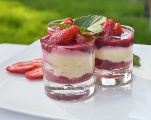 homemade strawberry tiramisu in glass on a table in a garden