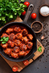 Meatballs in sweet and sour tomato sauce on the kitchen table. Top view