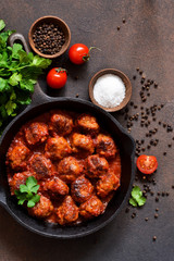 Meatballs in sweet and sour tomato sauce on the kitchen table. Top view