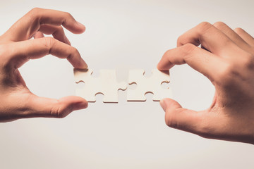 Pieces of jigsaw puzzle in woman's hands