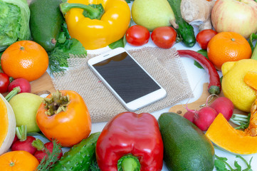 vegetables and fruits close-up in the middle of the smartphone, healthy food concept