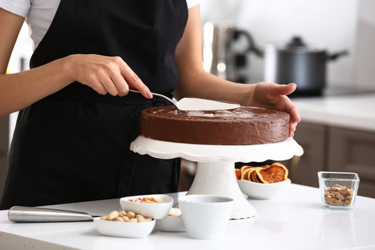 Young Female Confectioner Cooking Tasty Cake In Kitchen