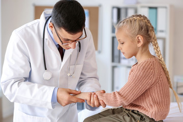 Fototapeta premium Pediatrician examining little girl in clinic