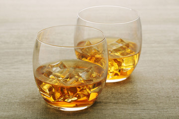 Two glasses with whiskey with ice cubes