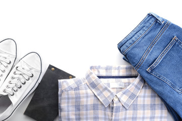 Jeans, shirt, shoes and notebook on white background