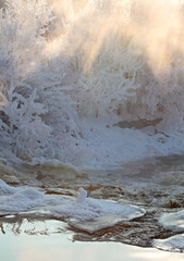 River flows through the rapid on a very cold January day . The air is full of frozen moisture