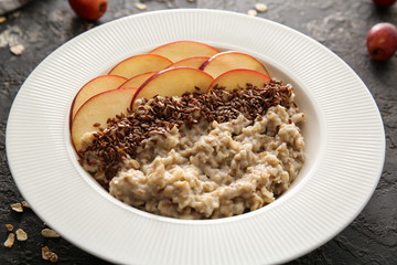 Plate with tasty sweet oatmeal on table, closeup