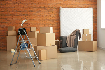 Moving boxes with belongings in empty room