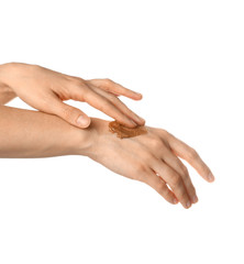 Woman applying sugar scrub onto hands against white background