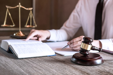 Male lawyer or judge working with Law books, gavel and balance, report the case on table in office,...