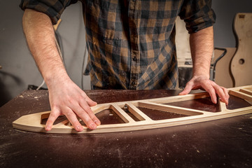 Home repair concepts. Close up of a young man carpenter builder equals a wooden bar with a milling...