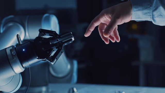 Futuristic Robot Arm Touches Human Hand in Humanity and Artificial Intelligence Unifying Gesture. Conscious Technology Meets Humanity. Concept Inspired by Michelangelo's Creation of Adam