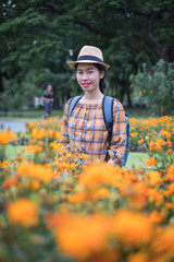 Naklejka na ściany i meble asian woman tourists. he is posing for a model fashion concept. in cosmos orange flower garden and tourist attractions. happily during travel the holidays and relax.