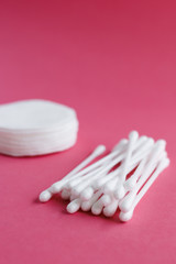 Cotton swabs and disks isolated on a pink background. Hygiene products.