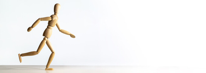 Fototapeta na wymiar Omino di legno che corre con sfondo bianco