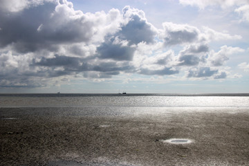 Obraz premium Das Watt in Büsum mit wolkigem Himmel