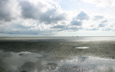 Obraz premium Das Watt in Büsum mit wolkigem Himmel