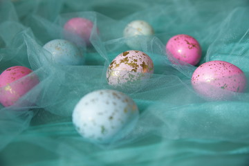 Colorful Easter eggs in a turquoise veil. Easter background.