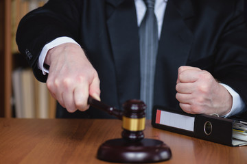 Judge man with documents and gavel on the table. Court listens to condemn and punish. Execution of a court sentence. Law and order.