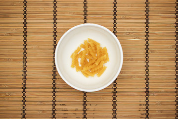 Pasta in white dish on wooden background