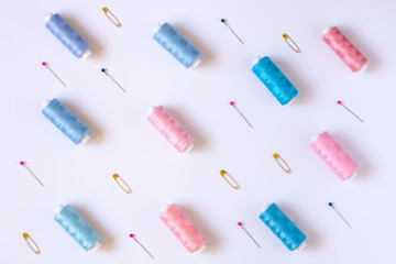 Sewing accessories for needlework in pink and purple and blue tones on white background