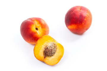 Group of ripe peach fruit and a half isolated on white background.