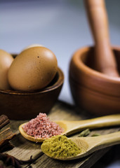 Blurred image of asian common ingredients  like fennel powder, pink salt, chicken eggs and mortar and pestle,