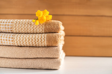 Fototapeta na wymiar Stack of beige towels on wooden background.