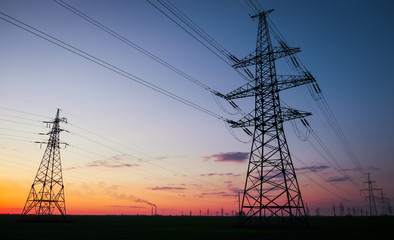 Silhouette High voltage electric towers at sunset time. High-voltage power lines. Electricity...