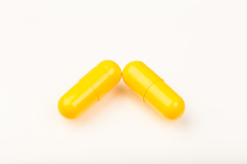 yellow capsules close up on white background