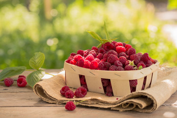  Small basket of fresh raspberries on natural