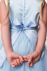 blaues kleid mit schleife und kinderhände