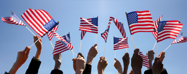 Group of People Waving American Flags over blue sky - Powered by Adobe