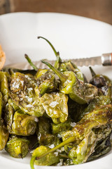 Green Padron Peppers with Crisp Bread in Rustic White Plate. Pimientos de Padrón.