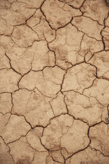 Texture of cracked red clay soil closeup, the concept of drought