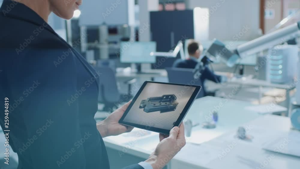 Fototapete Stylish Female Industrial Robotics Engineer Uses Tablet Computer with CAD Software and to Manipulate and Program Robot Arm for Lifting Moving Objects. Technology Research Facility for Machine Learning