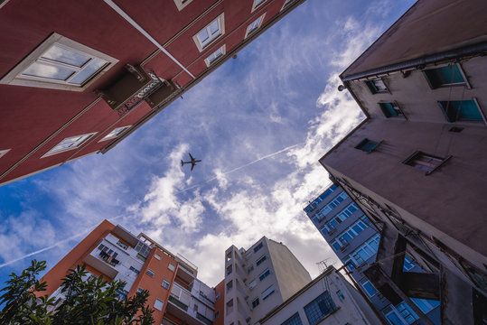 Passenger plane seen from a courtyard in Lisbon, capital city of Portugal