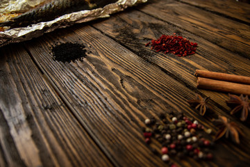 Baked mackerel with spices on a rough wooden background